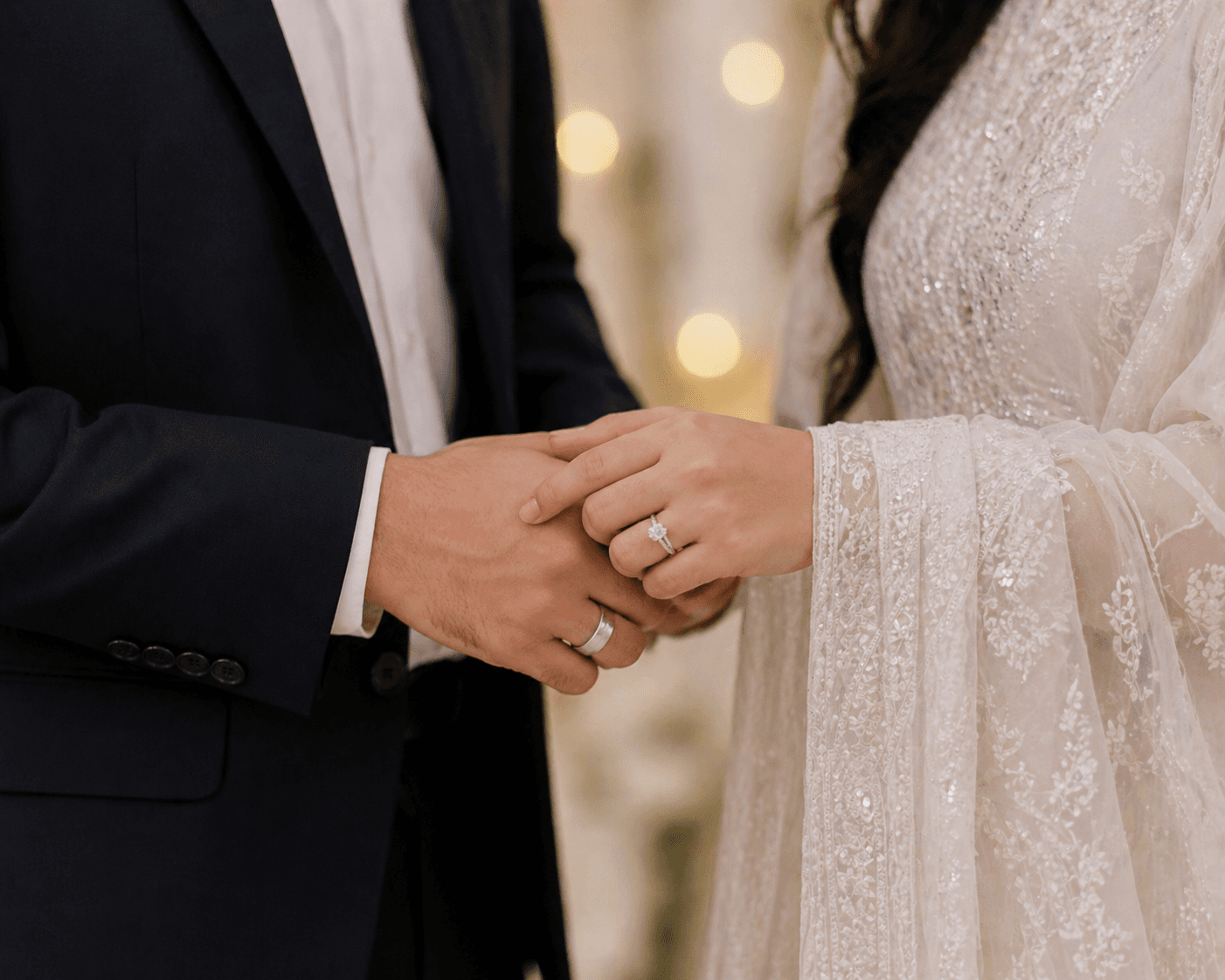 Bride and groom holding hands with wedding rings